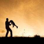 Silhouette of happy father having fun with his son